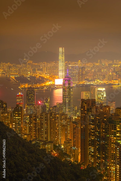 Obraz Hong Kong city and skyscrapers at night from a high mountaintop vantage point. The city lights create a stunning urban landscape.