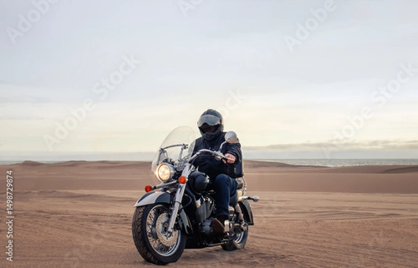 Fototapeta Man on motorcycle in desert during sunset with dramatic clouds — concept of freedom, travel, solitude, adventure, and outdoor lifestyle in wild open landscapes