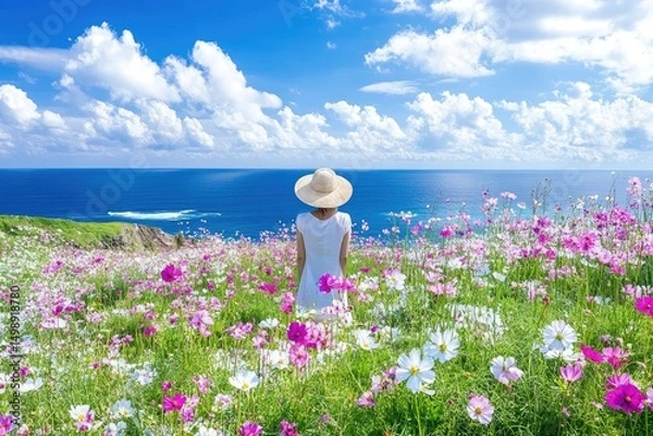 Fototapeta Relaxing woman standing amidst a colorful flower field overlooking the ocean.