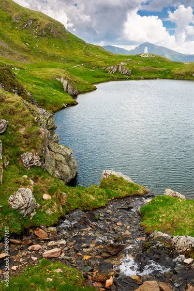 Fototapeta alpine lake in fagaras mountains. dramatic weather in transylvania highland. rippled water surface