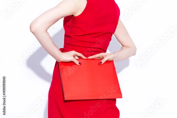 Fototapeta Closeup of Hands of Caucasian Business Woman in Long Red Dress Posing With Red Folder Over White