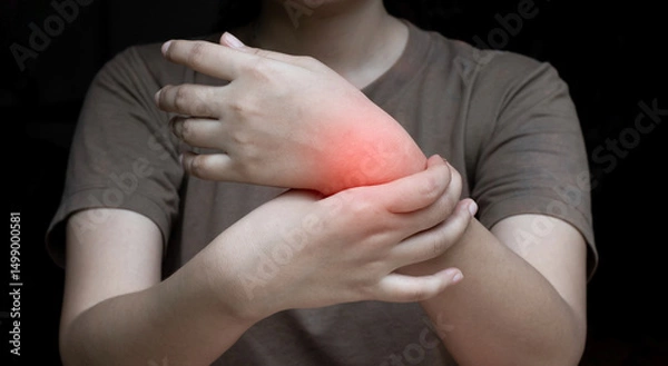 Obraz Person Holding Sore Wrist Experiencing Pain and Discomfort, Highlighted in Red.