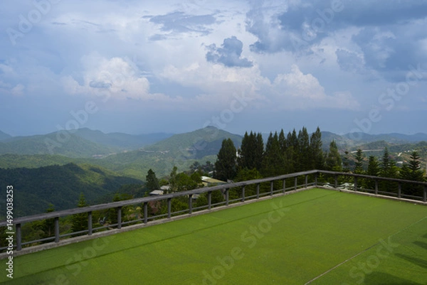 Obraz Scenic view of rolling green hills cloudy sky, showcasing vast landscape from balcony. serene atmosphere invites relaxation
