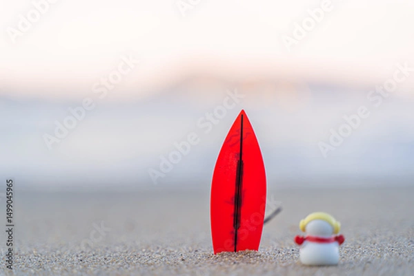 Fototapeta Sandy Christmas Snowman is watching the waves, standing on beautiful beach with a surf board - horizontal version in Patong Beach, Phuket, Thailand