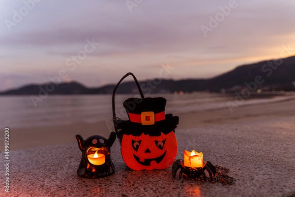 Fototapeta Concept: Halloween beach and ocean background with spider, witch and ghost pumpkin. Dark, scary tone.