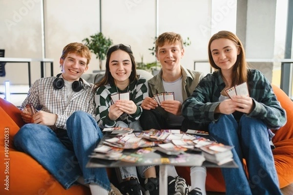 Fototapeta Group of students playing board game in a modern coworking space
