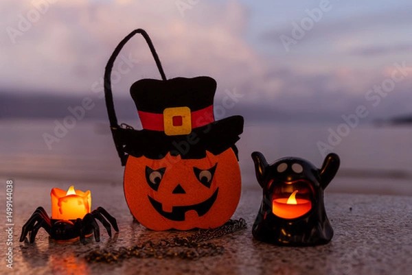 Fototapeta Concept: Halloween beach and ocean background with spider, witch and ghost pumpkin. Dark, scary tone.