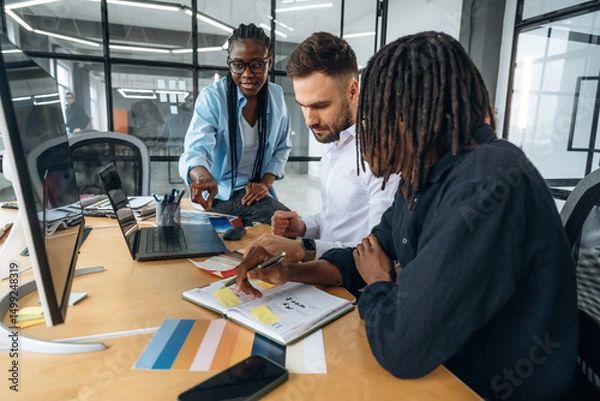 Fototapeta By the table with documents. Business people are working in the office