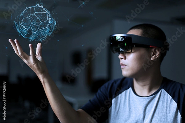 Fototapeta Trying Virtual Reality with hololens glasses.  Business man try virtual reality glasses in the dark room with advanced technology. Future technology concept. 