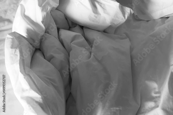 Fototapeta Clean crumpled white bed sheet and pillow after use in the bedroom. Image use for travel and resort business presentation background.
