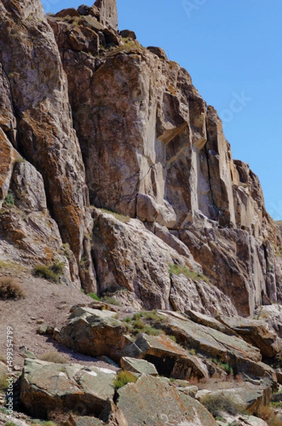 Fototapeta Massive Rock Formation in Dry Mountain Valley under Clear Deep Blue Sky with Sparse Vegetation