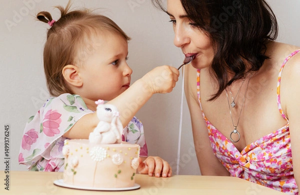 Fototapeta Two-year-old girl and mother with birthday cake