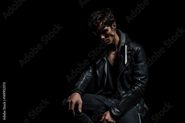 Fototapeta sad dramatic biker in leather jacket sitting