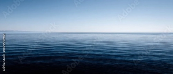 Fototapeta Calm blue ocean water with gentle ripples under a clear sky in a serene landscape view from a high angle perspective