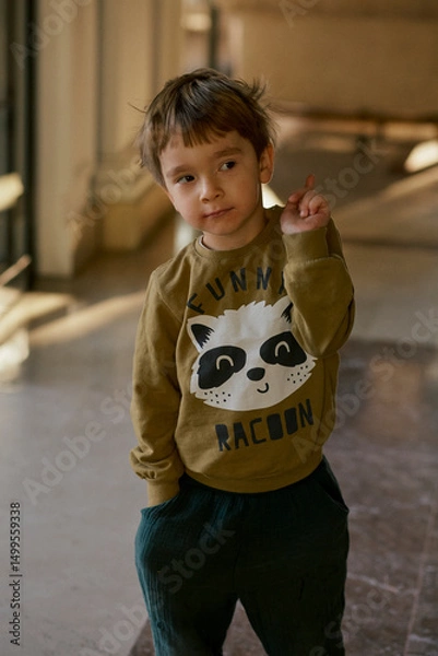 Fototapeta Little caucasian boy is playing in the hotel lobby by himself.