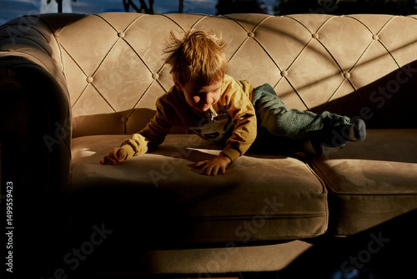 Fototapeta Little caucasian boy is playing in the hotel lobby by himself.