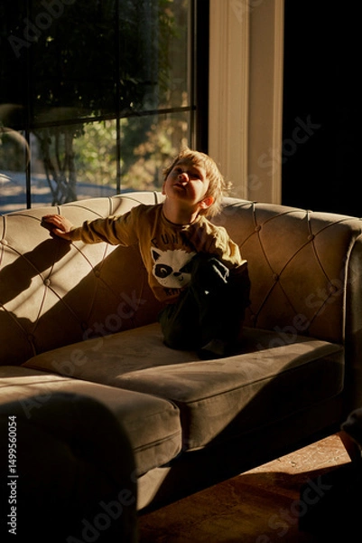 Fototapeta Little caucasian boy is playing in the hotel lobby by himself.