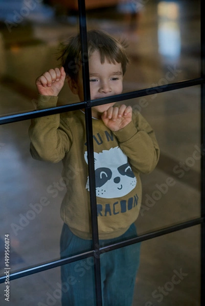 Fototapeta Little caucasian boy is playing in the hotel lobby by himself.