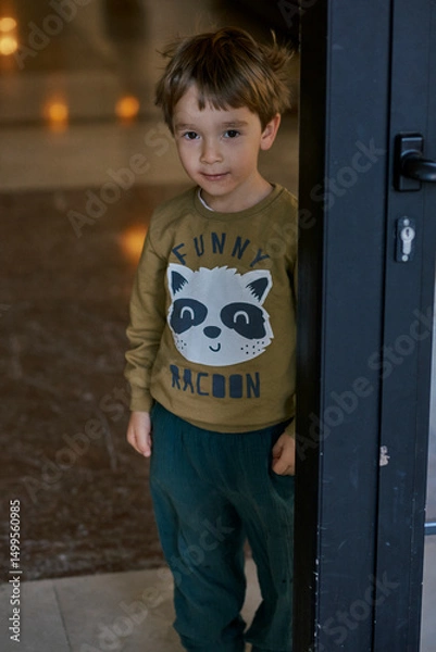 Fototapeta Little caucasian boy is playing in the hotel lobby by himself.