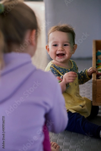 Fototapeta Little girl playing the constructor in the kid indoor  playground.