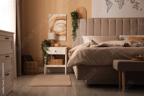 Fototapeta Nightstand with decor near bed in stylish room. Interior design