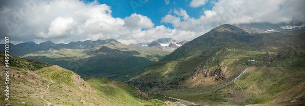 Fototapeta Panoramic mountain view with meadow and clouds