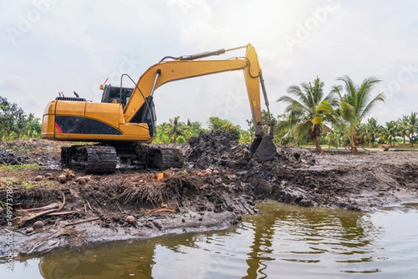 Fototapeta Construction work to adjust the area for agriculture. Excavator is working pipe laying and trench digging work in cultivation areas in lowlands Thailand.
