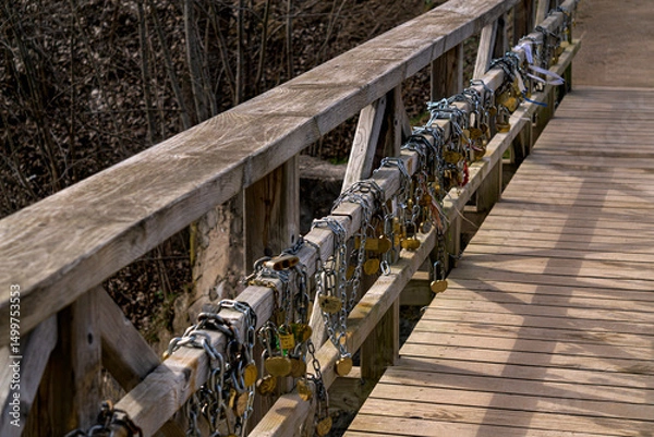 Obraz Old wooden bridge with iron locks on the fence, early spring.