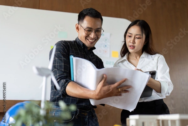 Fototapeta Sustainability and Engineering. Engineers sharing insights on eco-friendly designs in a collaborative space.