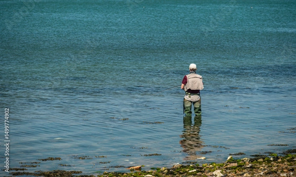 Obraz Lone fisherman in the sea at Langstone harbour, Hampshire, UK