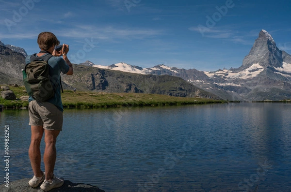 Obraz Boy taking pictures of the Stellisee lake in front of the Matterhorn, Switzerland