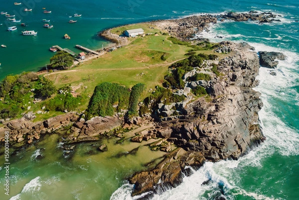 Fototapeta Rocky coastline with ocean and waves in Brazil. Drone view of Ponta das Campanhas in Floripa