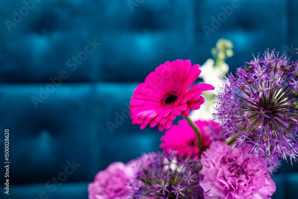 Fototapeta Bright flowers on a blue background in a modern setting