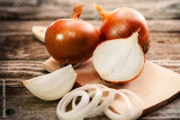 Obraz A sliced onion and fresh onions on cutting board