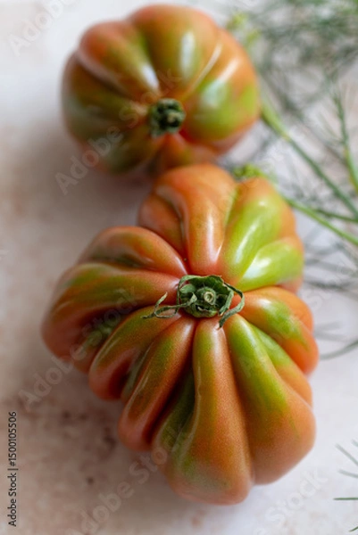 Fototapeta Close-up of an heirloom tomato and fennel, ideal for restaurant promotions. Use in menus or farm-to-table campaigns. Perfect for chefs, cafes, or organic dining marketing.