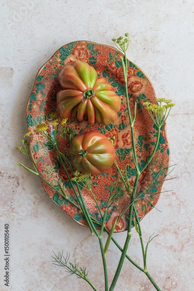 Fototapeta Vibrant tomatoes and fennel flowers on a patterned plate with this rustic setup, ready for social media food posts. Suited for grocery, organic products, or farmer’s market promotions.