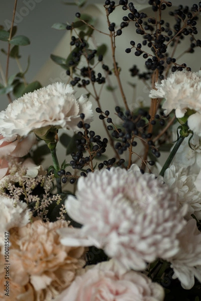 Obraz White carnation with black berries and soft pastel flowers. Elegant floral bouquet in natural light, perfect for background or design.