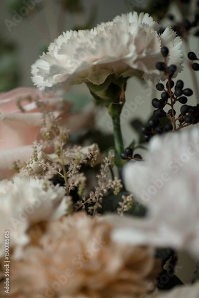 Obraz White carnation with black berries and soft pastel flowers. Elegant floral bouquet in natural light, perfect for background or design.