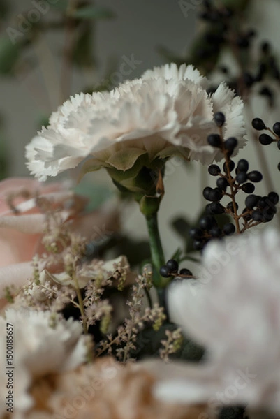 Obraz White carnation with black berries and soft pastel flowers. Elegant floral bouquet in natural light, perfect for background or design.