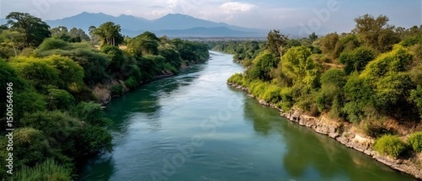 Obraz Serene river valley with distant mountains