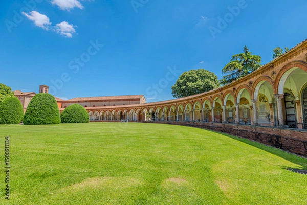 Fototapeta Saint Christopher Church in Charterhouse of Ferrara features a stunning Renaissance porch with elegant arches and columns, alongside a tall bell tower under a clear blue sky in Ferrara city of Italy