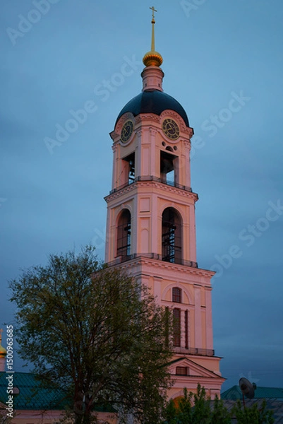 Fototapeta A tall tower with a clock on it