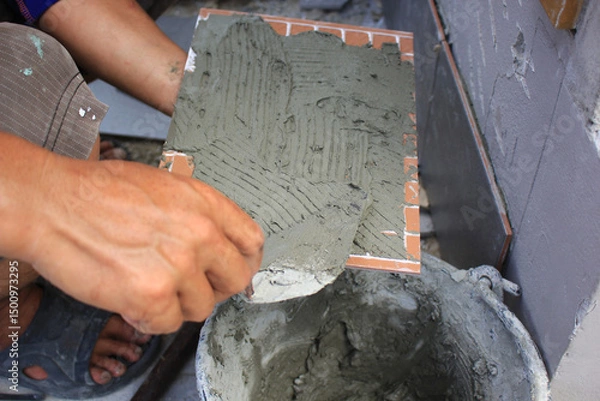 Obraz Bricklayer laying mortar on a brick wall at construction site