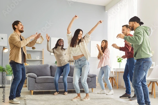 Fototapeta Dancing friends group at home, people enjoy fun, happy dance entertainment, party gathering, students wearing formal wear, event celebration, enjoyment, amusement, enjoyable gathering in living room