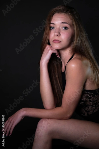 Obraz posing on elbows against a black background