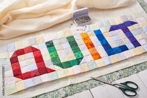 Obraz The word quilt sewn from colorful square and triangle pieces of fabric