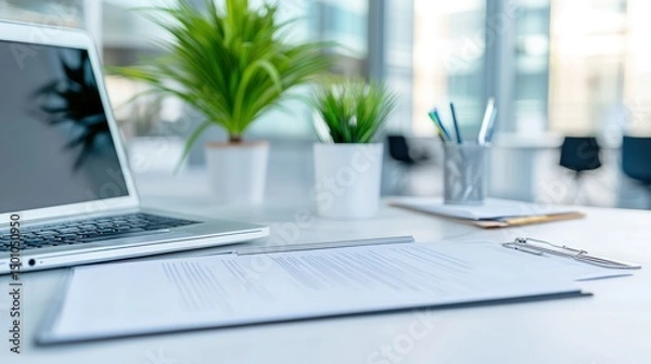 Fototapeta Laptop and documents on desk in bright office environment for business finance work