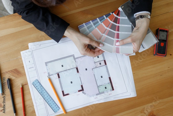 Fototapeta Architect reviewing interior design options for residential projects on design plans at workspace