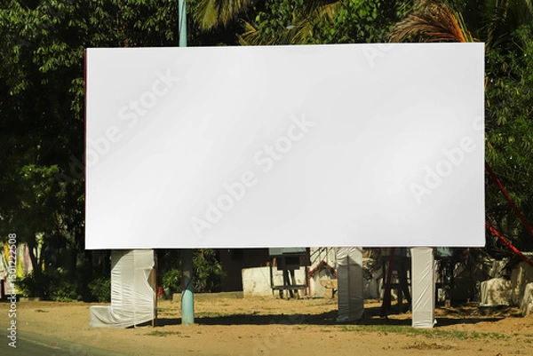 Fototapeta billboard on city road, outdoor advertising, mockup billing board in front of green tree and Blank white background for branding design large hoarding, Outdoor advertising construction. india.