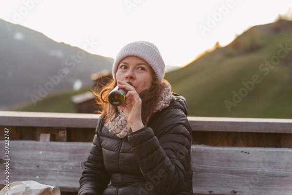 Fototapeta Tourist drinking beer enjoying mountain view at sunset